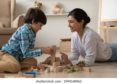 Smiling Indian mother and little biracial son sit on floor at home play with building block bricks together. Happy mixed race ethnicity mom and small ethnic boy child engaged in playful game activity. - Powered by Shutterstock