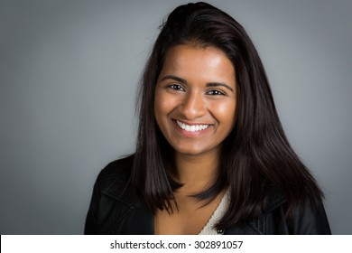Улыбающаяся индийская женщина на сером фоне