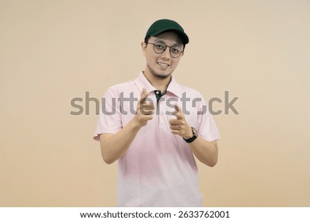 smiling individual pointing with a friendly expression in casual attire