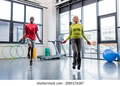 Smiling interracial people training with jump ropes in gym - Powered by Shutterstock