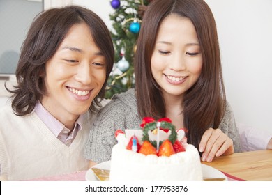 Smiling Japanese Couple Looking At A Christmas Cake