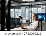 Smiling junior IT specialist writing code, developing machine learning APIs. Upbeat young female technician working in office, troubleshooting software errors using artificial intelligence tech