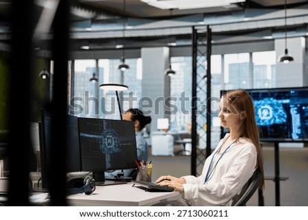 Smiling junior IT specialist writing code, developing machine learning APIs. Upbeat young female technician working in office, troubleshooting software errors using artificial intelligence tech