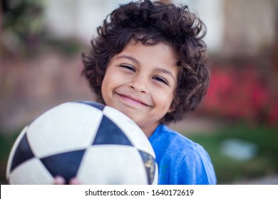 Smiling kid boy in blue t-shirt holding ball outdoor. Children, sport and activity concept