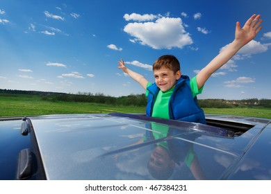 Smiling Kid Boy Enjoying Freedom On Sunroof Of Car