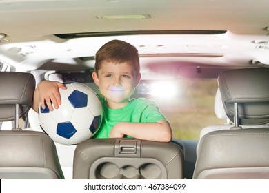 Smiling Kid Boy Holding Soccer Ball Inside The Car