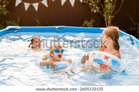 Smiling kid having fun in pool on colorful inflatable toy at summer day.