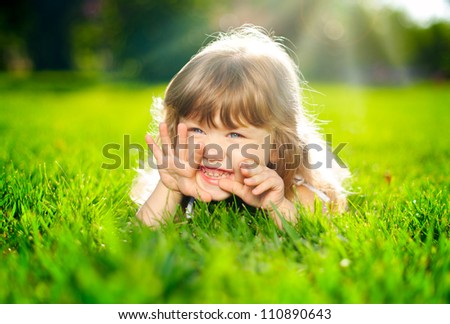 Similar – Littel girl sitting on grass looking curious