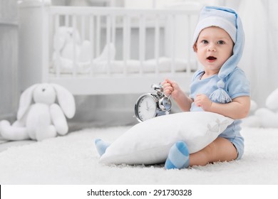 Smiling Kid In The Nightcap With An Alarm Clock And A Pillow On The Carpet In My Room