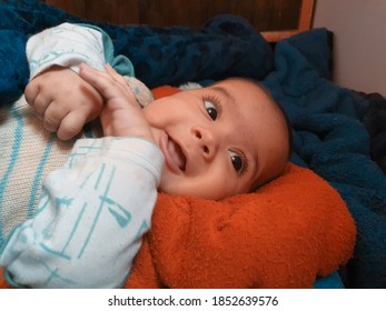 Smiling kid photographs at home under blanket looks beautiful.