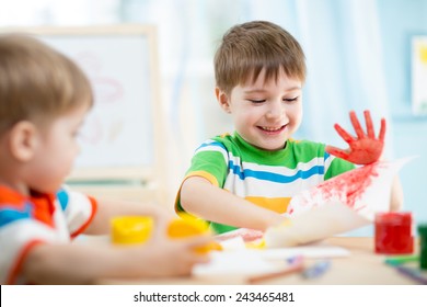 Smiling Kids Playing And Painting At Home Or Kindergarten Or Playschool