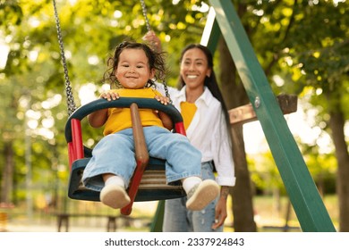 Smiling Korean Mother Swinging Baby Toddler Girl On The Swing, Riding Adorable Child Daughter And Having Fun On Outdoor Playground. Weekend With Mom, Activities For Mommy And Kid. Selective Focus - Powered by Shutterstock