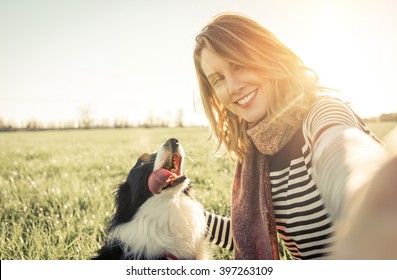 Smiling lady taking selfie with her dog. Woman and her loyal border collie dog - Powered by Shutterstock