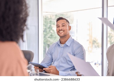 Smiling latin young business man hr bank manager, company worker or financial advisor holding digital tablet consulting client, listening at team work office meeting or job interview sitting at table. - Powered by Shutterstock