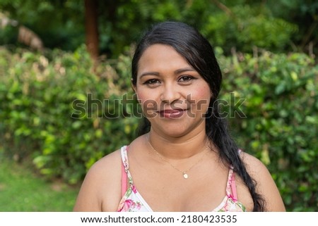 Smiling latina woman in dress standing in park ストックフォト © 