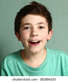 Smiling Laughing Preteen Boy With Mouthful Of Healthy White Teeth Close Up Portrait In Blue T-shirt