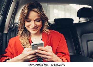 Smiling And Laughing Woman Texting To Her Boyfriend Or Friend A Message. Passenger Using An App 
