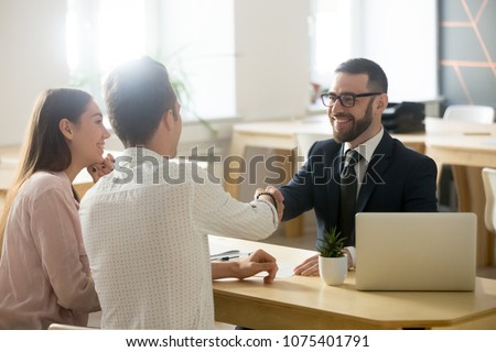 Smiling lawyer, realtor or financial advisor handshaking young couple thanking for advice, insurance broker or bank worker and millennial customers shake hands making deal, investment or taking loan