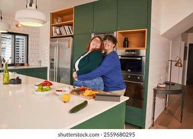 Smiling lesbian couple embracing in kitchen - Powered by Shutterstock