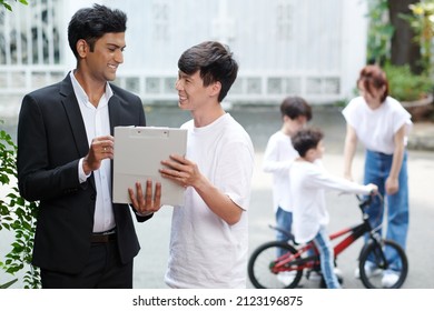 Smiling Life Insurance Agent Explaining Client How To Fill Policy For All Family Members