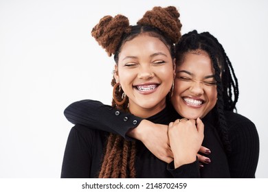 Smiling Lights Up The Face. Studio Shot Of Two Beautiful Young Women Posing Against A Grey Background.