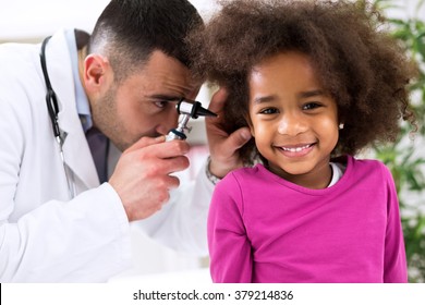 Smiling little african girl with mid age ear specialist - Powered by Shutterstock