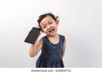 Smiling little asian girl kid showing blank screen of new popular mobile phone on white background. Excited Asian cute girl is using a smartphone, Phone empty screen display mockup. - Shutterstock ID 2210019721