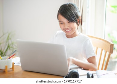 Smiling Little Asian Girl Using Laptop To Learning Online At Home And Typing On Keyboard Homeschool Concept