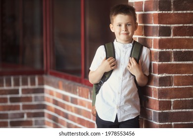 Smiling Little Boy 6-7 Years Old Goes To School In Uniform And Backpack