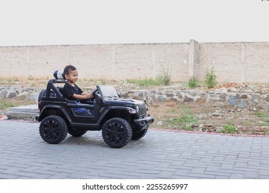Smiling little boy in casual style on car toy at the park  - Shutterstock ID 2255265997