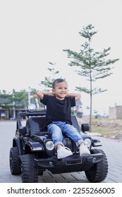 Smiling little boy in casual style on car toy at the park  - Shutterstock ID 2255266005