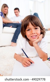 Smiling little boy drawing lying floor in the living room