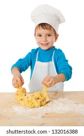 Smiling little boy kneading the dough on the table, isolated on white
