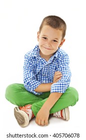 Smiling Little Boy Sitting Down On Floor And Looking At Camera. Isolated On White Background 