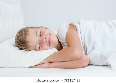 Smiling Little Boy Sleeping On The Bed