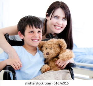 Smiling little boy in a wheelchair with his mother in a hospital - Powered by Shutterstock