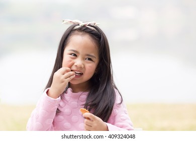 Smiling Little Girl Eating Cookie