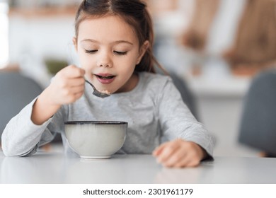 Smiling little girl eating her breakfast, made by her dad. - Powered by Shutterstock