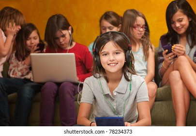 Smiling little girl with video game on a console with friends behind her - Powered by Shutterstock