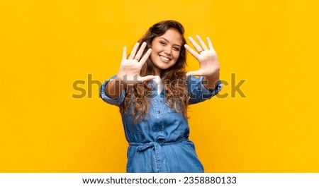  smiling and looking friendly, showing number ten or tenth with hand forward, counting down