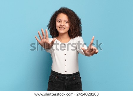  smiling and looking friendly, showing number seven or seventh with hand forward, counting down