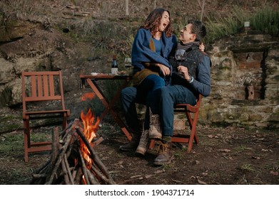 Smiling In Love Couple Eating And Drinking Wine In The Garden With Bonfire