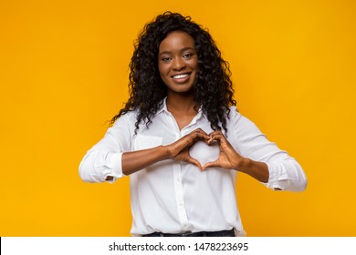 Smiling Loving Black Woman Shaping Hands Like Heart On Yellow Background