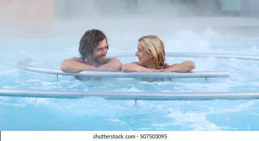 Smiling loving couple relaxing together on a jacuzzi pool at spa