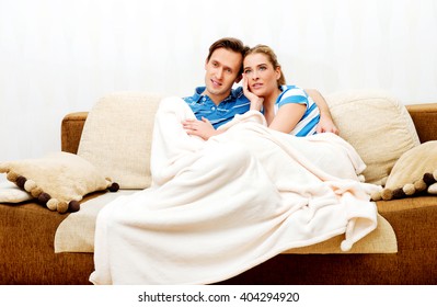 Smiling Loving Couple Sitting On Couch With Blanket