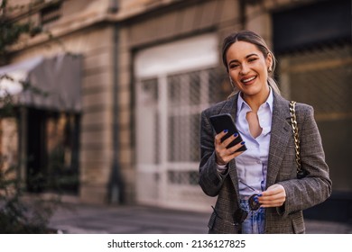 Smiling With A Low Ponytail, Dressed Elegantly, Using The Phone.