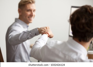 Smiling Male Colleagues Fist Bumping At Workplace, Happy Friends Greeting, Partners Sharing Success, Employees Celebrating Good Teamwork Result, Workers Supporting Motivation Concept, Close Up View