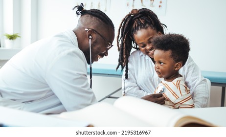 Smiling Male Doctor Listen Consult Cute African Boy Make Notes In Patient Card At Medical Checkup Appointment, Black Mother And Child Son Visit Pediatrician Talk In Clinic, Children Healthcare Concept