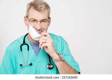 Smiling male doctor removing his surgical mask - Powered by Shutterstock