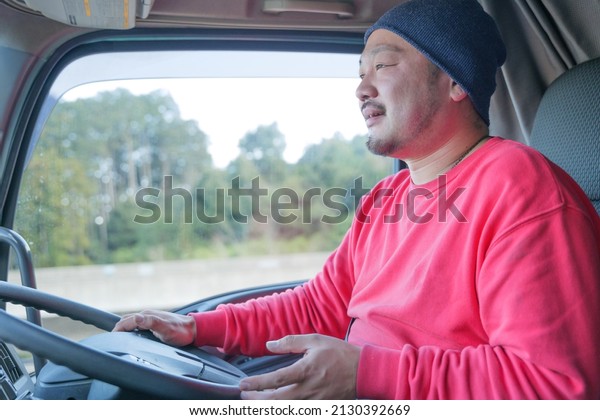 Smiling male driver\
driving heavy truck